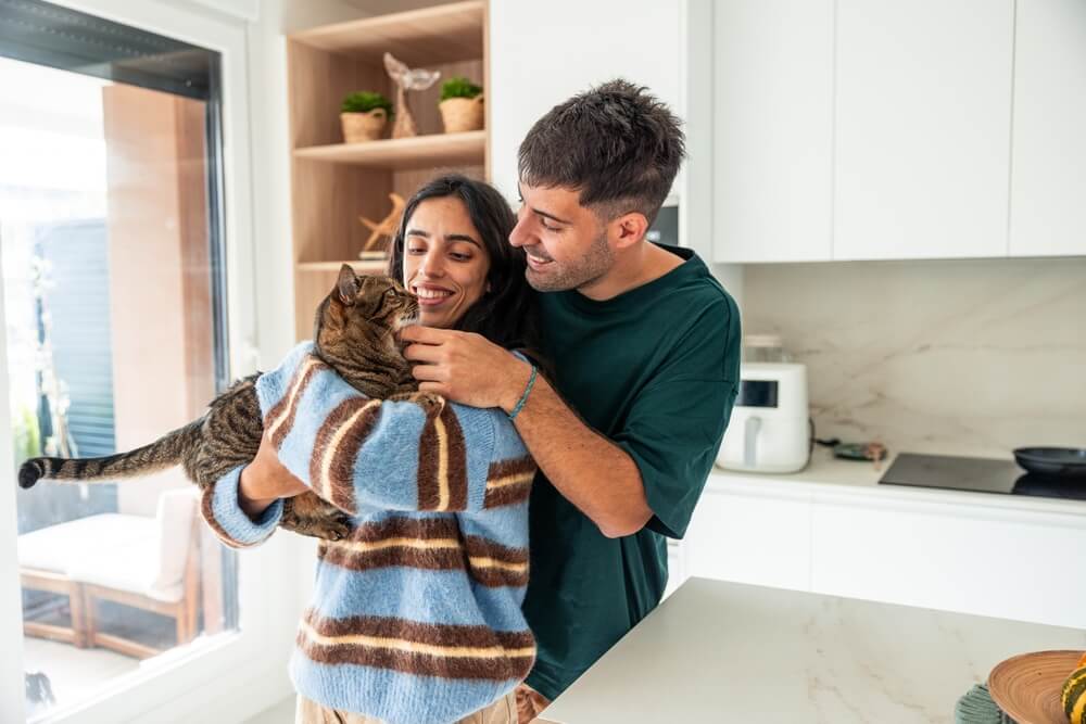 Gastos inesperados de tener mascotas en USA para una pareja que cuida a su gato en casa.